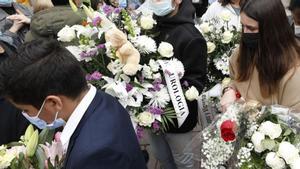 Compañeros y amigos de Erika Yunga salen de su funeral en la capilla de la residencia María Inmaculada, el 7 de abril de 2022, cargados de ramos y coronas de flores.